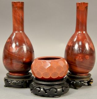 Three red agate pieces to include a pair of pear shaped vases with slender elongated necks (one broke and repaired) and a sma