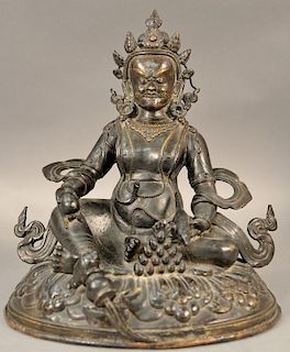 Large Chinese bronze Buddhist figure seated atop a pedestal with flowing robes, holding an egg in his right hand and a rat in