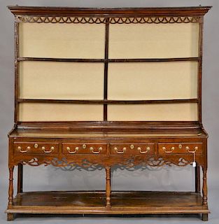 Welsh cupboard in two parts, upper portion having cornice molded top with lattice work carved front and two shelves on base w