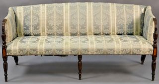 Sheraton mahogany sofa having partial open arms with panel inlays on turned fluted legs, circa 1830. 
ht. 36in., wd. 76in.