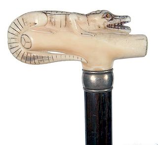 10. Walrus Alligator Cane- Ca. 1910- A full length carved gator with two color glass eyes, silver collar, exotic hardwood sha
