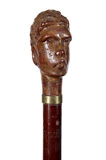 56. African Wood Dress Cane- A carved African warrior with metal earrings, brass collar, exotic wood shaft and a horn ferrule