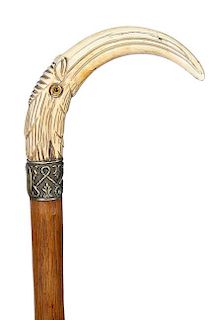 89. Wild Boar Bird Cane- Ca. 1880- A carved “pig ivory” bird cane with two color glass eyes, ornate, high relief silver m