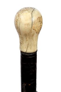108. Nautical Tooth Cane- Ca. 1870- A nice patinaed whale’s tooth handle, brass washer collar, stacked leather shaft and a 