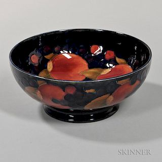 Moorcroft Pomegranate Footed Bowl, England, c. 1925, polychrome enamel decorated to a dark blue ground, painted signature and