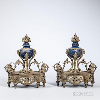 Pair of Louis XV-style Bronze Chenet, late 19th/early 20th century, each with flame finial on an blue painted urn with ram's 