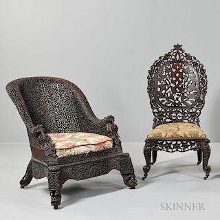 Two Anglo-Indian Carved Hardwood Chairs, each overall heavily carved, one canted barrel-form with scrolled crest rail, slopin