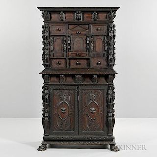 Continental Baroque-style Carved Walnut Cabinet, possibly late 19th century, rectangular top projection over figural mounted 