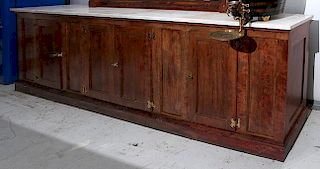 Backbar 42" h x 18" w x 11'5" l Soda shop back bar with a two piece white marble top, four compartments with brass hinges and