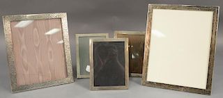 Five sterling silver picture frames including Shreve Crump & Low with incised flower decoration, set of three medium sized fr