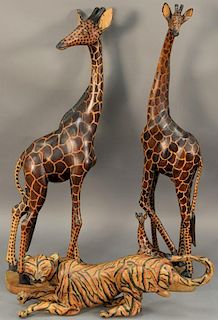 Three piece lot to include two carved giraffes and a tiger. giraffes: ht. 35in., tiger: 22 1/2in.