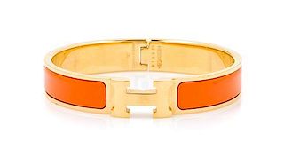 An Hermes Orange Enamel Clic Clac PM Bracelet, 6.5" x .5".