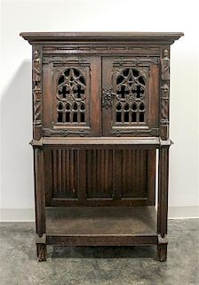 A Gothic Revival Oak Court Cupboard Height 53 1/2 x width 35 1/2 x depth 19 inches.