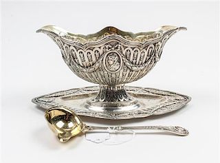 * A German Silver Sauce Boat and Ladle, Late 19th/Early 20th Century, each chased with garlands suspending a central portrait