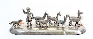 A Peruvian Silver Figural Group, , depicting a shepherd and his dog with a herd of llamas.