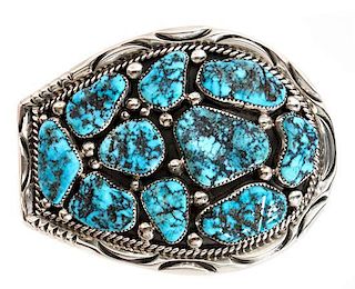 A Navajo Silver and Turquoise Belt Buckle, Orville Tsinnie (1943-2017) Height 3 x width 4 inches.