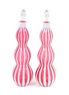 A Pair of Cranberry Rib Optic Bottles Height 14 1/4 inches.