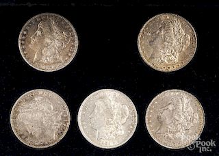 Five Morgan silver dollars.