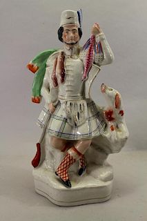 Staffordshire figure of kilted Scotsman with Dog