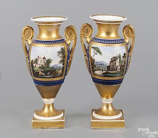 Pair of Paris porcelain vases, ca. 1830, each with landscape decorated panels on gilt grounds