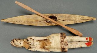 AN ESKIMO DOLL AND HIDE KAYAK WITH WOOD PADDLE
