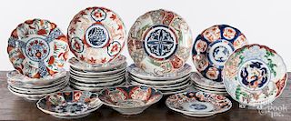 Thirty Imari plates and shallow bowls