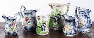 Six relief decorated Staffordshire pitchers