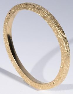 14 karat gold bangle bracelet with overall etched flowers and scrolls