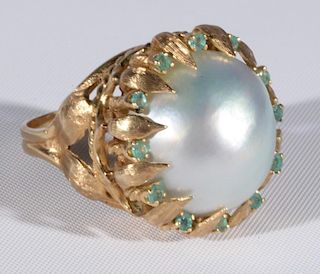 14 karat gold ring set with large Mobe pearl surrounded by small green stones. size 6