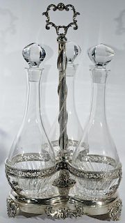 Large silver trefoil form three bottle decanter set, caddy having cut crystal liquor bottles with stoppers, marked bottom pla