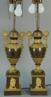 Pair of bronze and gilt bronze urns made into table lamps, set on square bases with classical gilt figures. urn ht. 19 3/4in.