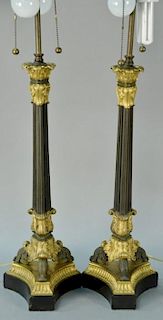 Pair of bronze and gilt bronze table lamps having two lights each on gilt bronze corinthian over three columns, set on scroll