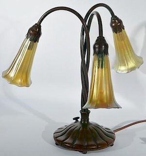 Tiffany bronze three light lamp with art glass shades (replaced shades). ht. 13in. Provenance: Property from the Estate of Fr