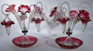 Two Victorian clear to ruby flash art glass epergnes having ruffle edge bowl with metal ring supporting three vases and three