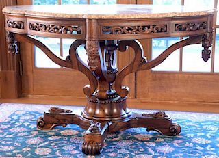 Rosewood shaped marble top table having pierce carved skirt with finials, on supports set on pedestal on an X base with scrol