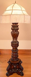 Large carved mahogany floor lamp with custom silk shade having acanthus carved column set on carved base with paw feet. ht. 6