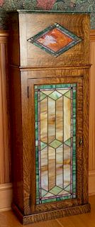 Oak cabinet with marble top, stain and leaded glass panel over stained and leaded glass door with lights on inside. ht. 58in.