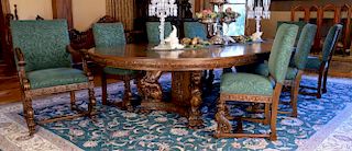 Oak nine piece dining set with round table having winged griffin carved split pedestal with foliate carved panels and apron,