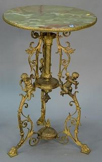 Onyx top table with bronze edging on bronze base with putti all on claw feet. ht. 31in., dia. 20in. Provenance: Property from