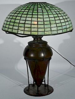 Tiffany Studios Geometric leaded glass shade on oil lamp base having central urn supported by five legs on round font, marked