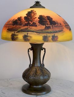 Reverse painted table lamp on large urn form metal base with scenic shade. ht. 23in., dia. 19in. Provenance: Property from th