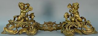 Pair of large Louis XV bronze chenets with figural putti figures holding shells with rococo center bar, 19th century