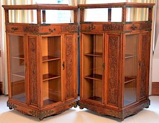 Pair of Aesthetic oak revolving bookcases, each of four sides with drawer and glass locking door brass mounts with foliate ca