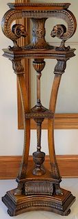 Mahogany fern stand with shaped top supported by carved ram's heads and rectangular legs on hoof feet set on shaped base. ht.