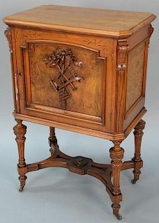 Renaissance Revival walnut music cabinet having carved musical door and burled panels all on turned legs. ht. 39 1/2in., top: