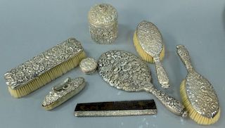 Tiffany & Co. sterling silver eight piece dresser set, floral repousse comprising of a hand mirror, hair brushes, comb, two h