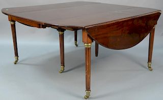 Continental mahogany drop leaf table having oval drop leaves set on fluted brass capped legs with six 25 1/2 inch leaves, ht.