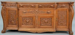 Large Victorian oak sideboard having foliate carved drawers and doors flanked by carved lion heads on paw feet