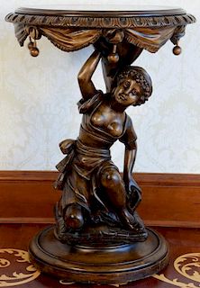 Large figural walnut pedestal with circular top held by carved female figure kneeling on pillow set on round base, 20th centu