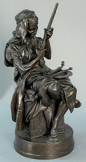 After Emile Edmond Peynot (1850-1932) french bronze figure "Le Marchand Tunisien" a man seated cleaning his gun, having Arabi